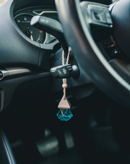 Hanging car freshener blue bottle by the indicator stick