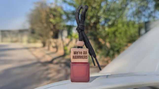 dissipating smell from a red square matte car air freshener bottle